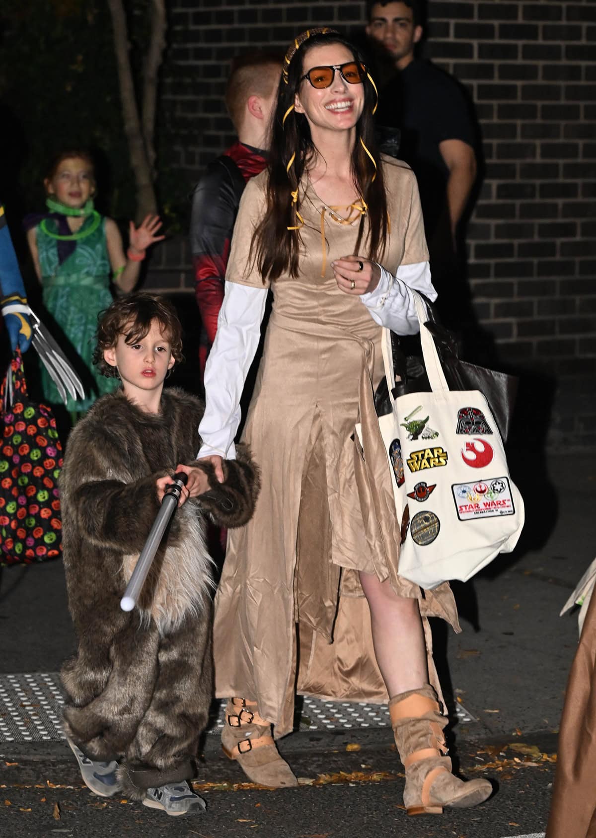 Anne Hathaway channels a modern Princess Leia for Halloween in New York on October 31, 2024, pairing a draped tan dress with iconic Vivienne Westwood Pirate boots