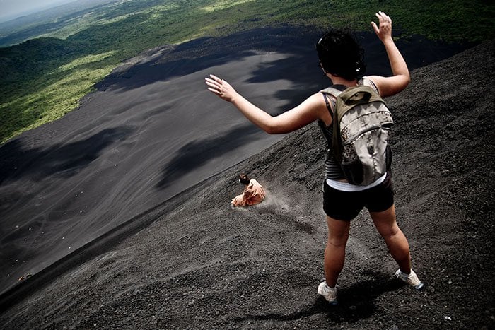 Thrill-seekers volcano-boarding on the slope of the crater of Cerro Negro volcano in Nicaragua