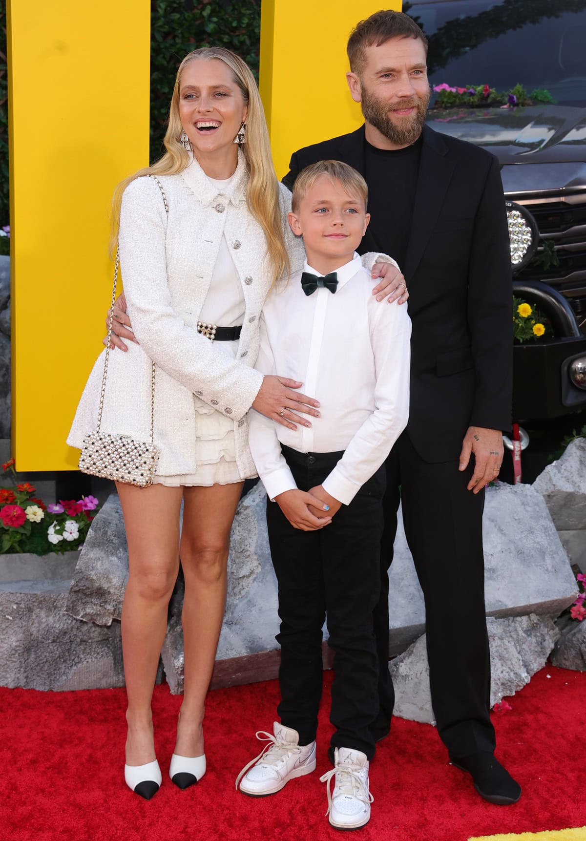 Teresa Palmer stuns in a Chanel tweed jacket and ruffled mini dress, paired with chic cap-toe pumps and a pearl-embellished bag, as she attends The Fall Guy premiere in Los Angeles with her husband, Mark Webber, and their son, Bodhi Rain Webber