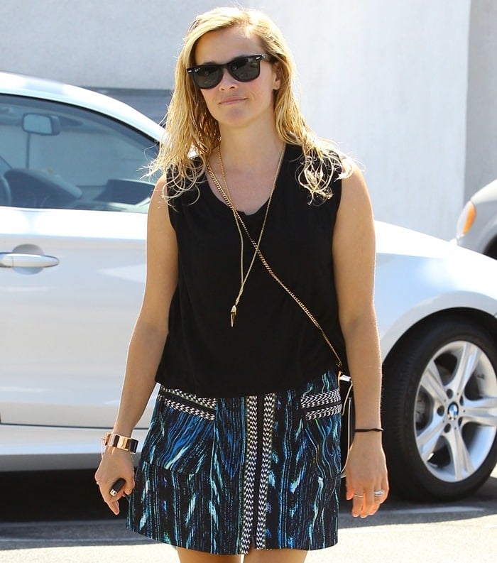 Reese Witherspoon wearing a black blouse and a blue jacquard miniskirt by Kenzo