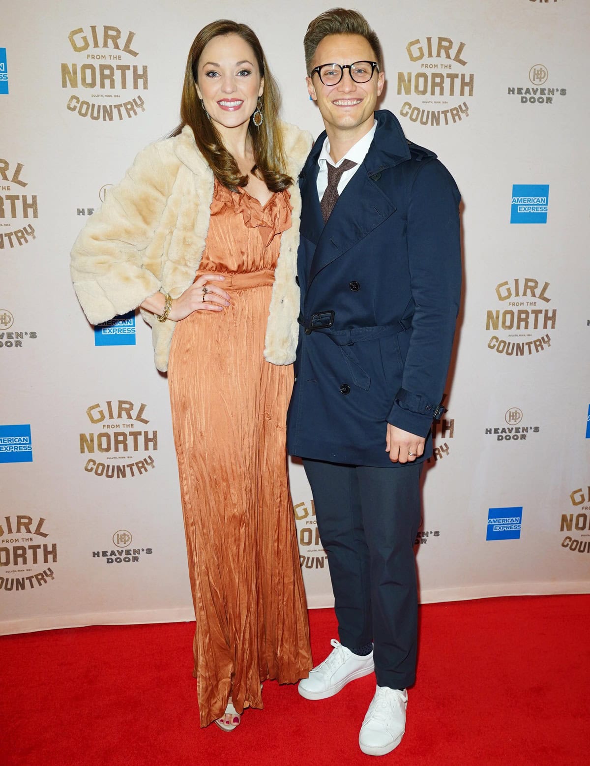 Laura Osnes stuns in a flowing copper gown paired with a chic faux fur jacket, while Nathan Johnson opts for a sharp navy trench coat and white sneakers as the couple attends the 'Girl From The North Country' Broadway opening night at the Belasco Theatre on March 5, 2020, in New York City