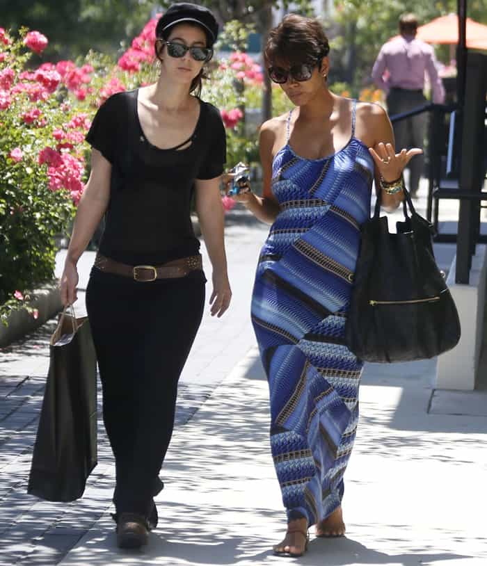 Halle Berry elegantly showcases her baby bump in a blue patterned Heartloom Olivia maxi dress, paired with simple sandals and a chic black tote