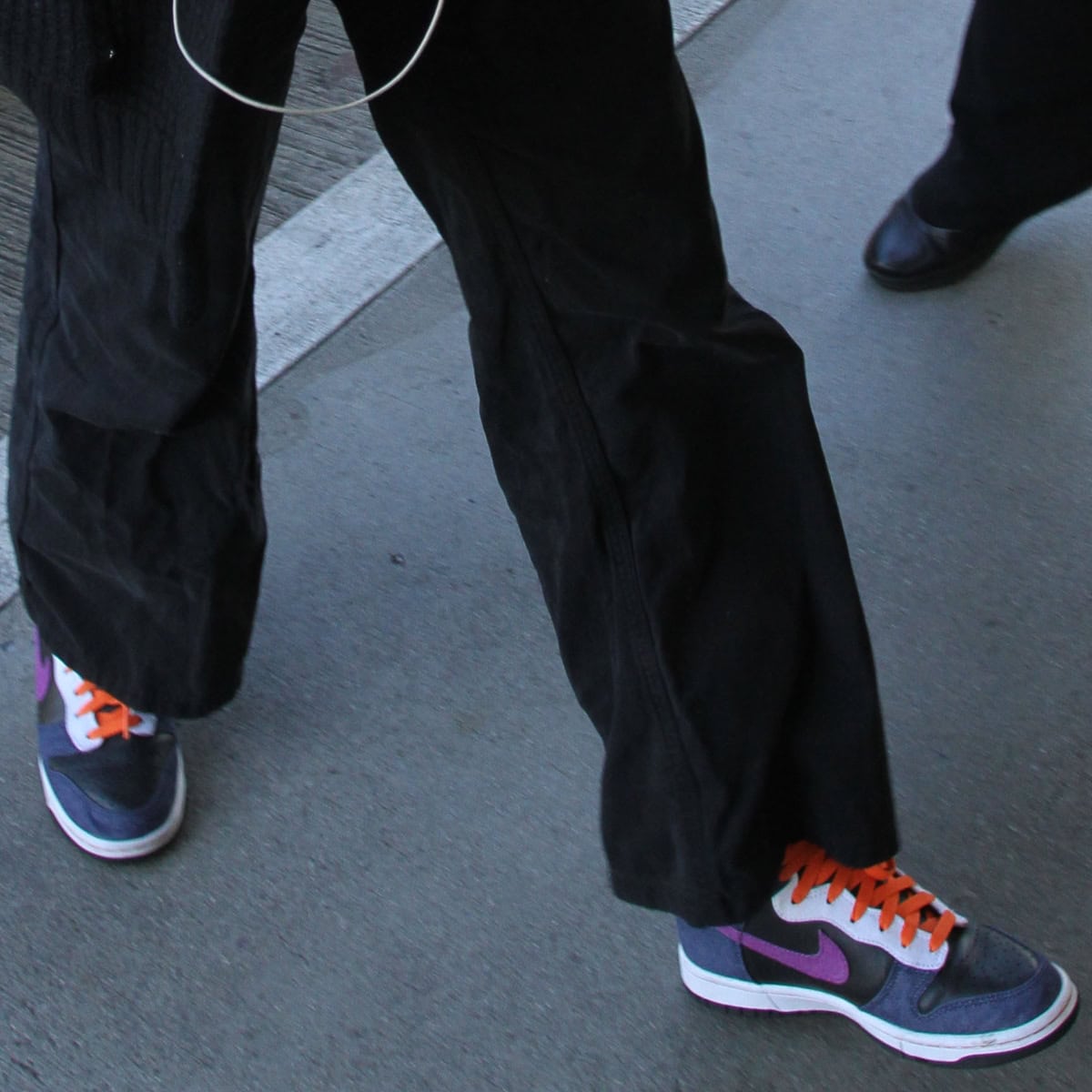 Kerry Washington wore Nike Dunk Low sneakers featuring a dark grey color with vibrant orange laces and purple accents