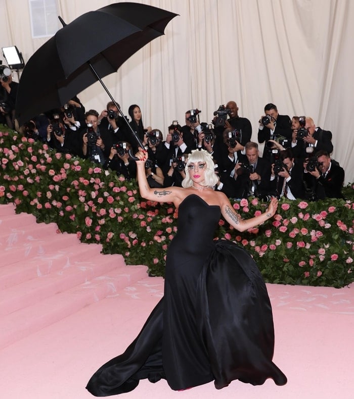 Lady Gaga wears an all-black ensemble with a matching umbrella at the 2019 Met Gala