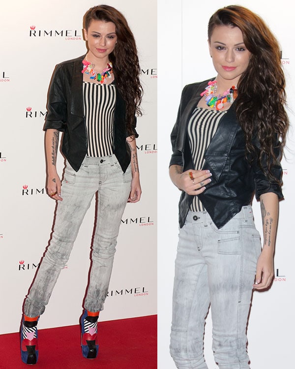 Cher Lloyd showcases her bold fashion sense at the Rimmel London event, pairing a striped top with a sleek leather jacket, statement necklace, and colorful platform heels at Battersea Power Station in London