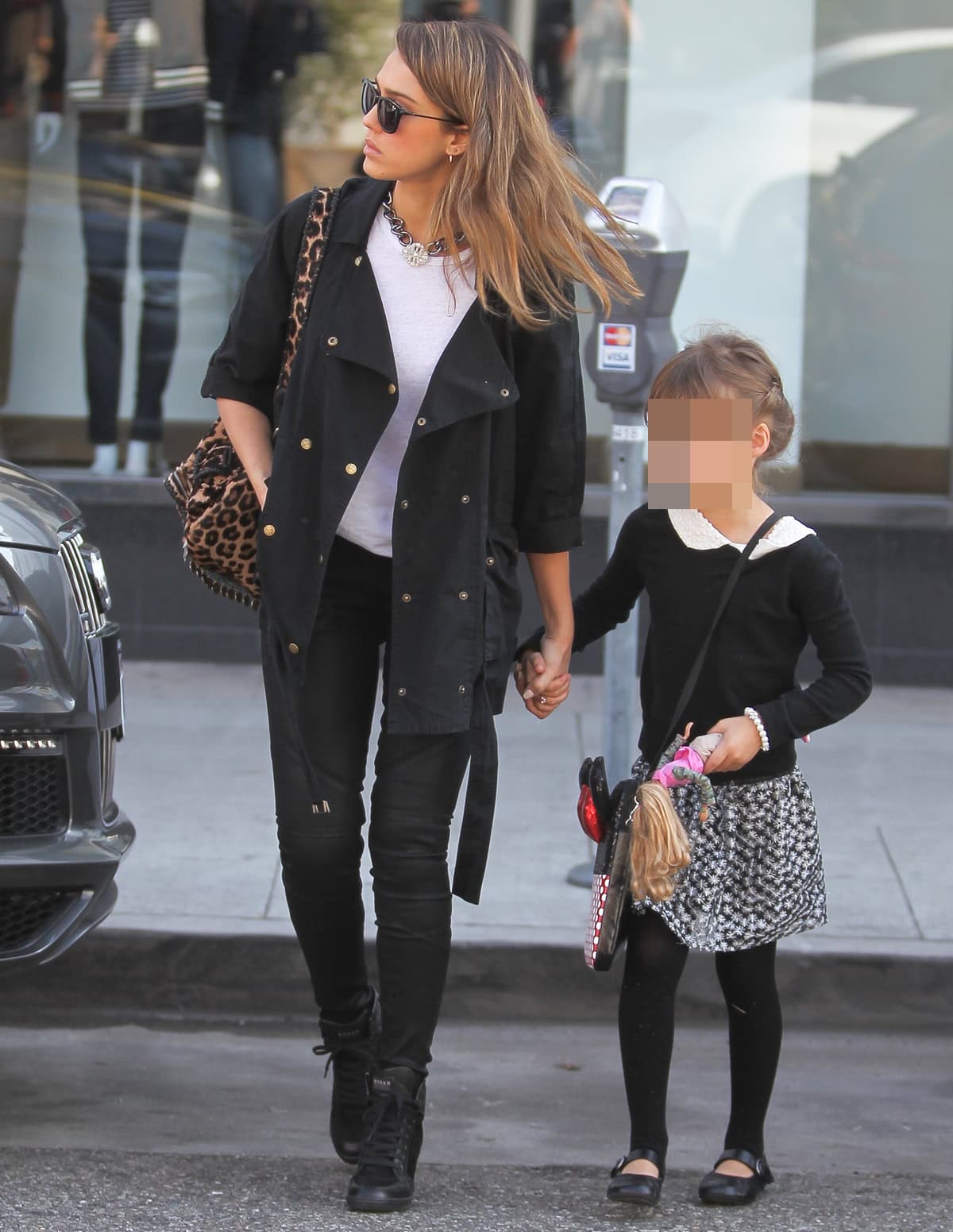 Jessica pairs a white top with black skinny jeans, a matching coat, and black sneakers, while Honor complements her mom's look with a collared top, patterned skirt, and Mary Jane flats