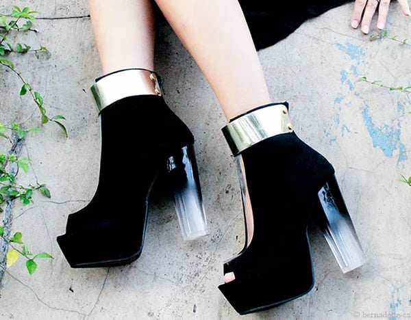 Her boots feature clear PVC panels down the front and gold-tone metal plates at the cuffs