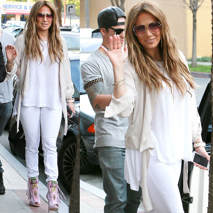 Jennifer Lopez waves to the paparazzi in an all-white ensemble with pink beaded booties