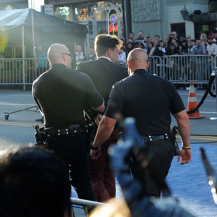 Police arresting and leading away Vitalii Sediuk, the man who jumped the barriers and tried to make contact with Brad Pitt's face as the actor walked down the red carpet