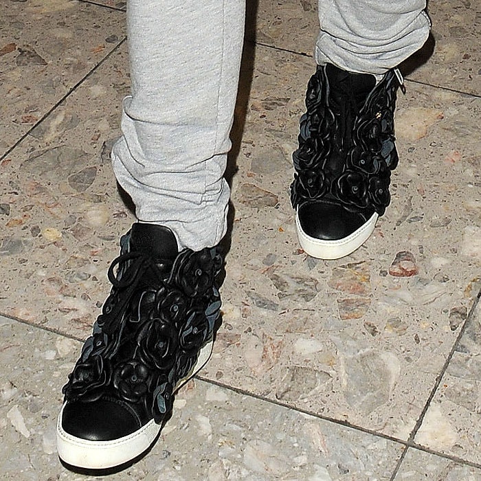 Rita Ora's Chanel 'Camellias' high-top sneakers add a stylish and luxurious touch to her casual gray sweatpants