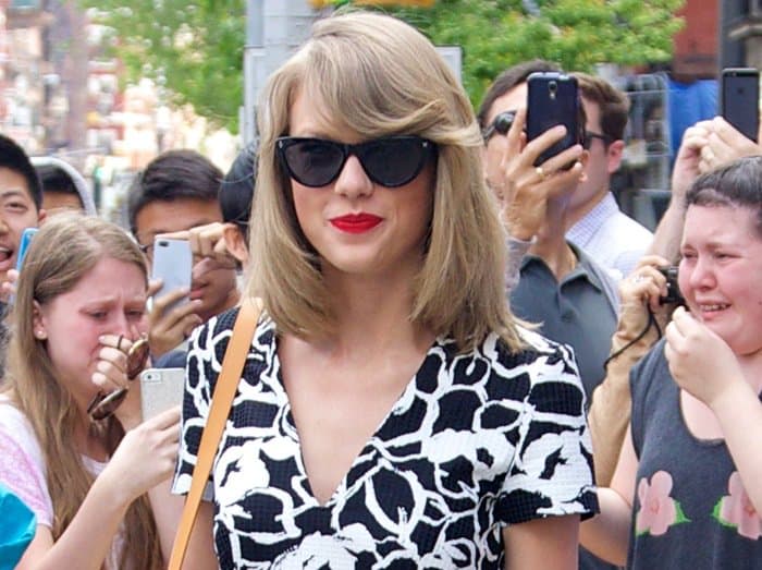 Taylor Swift shows off her black "Agagta" shoulder bag by Dolce & Gabbana and Ray-Ban sunglasses