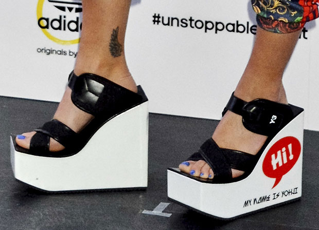 Rita Ora wearing Y-3 wedge sandals with Hi! My Name Is Yohji print