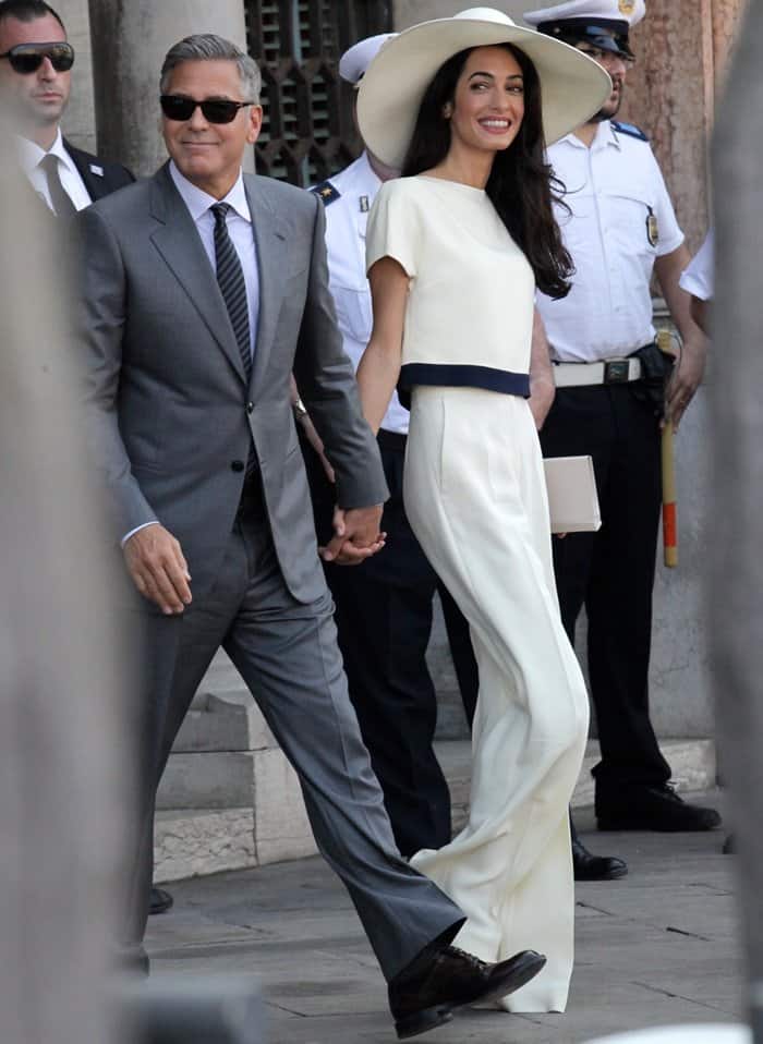Amal Alamuddin looks effortlessly chic in a custom Stella McCartney suit and wide-brimmed hat, holding hands with George Clooney in Venice