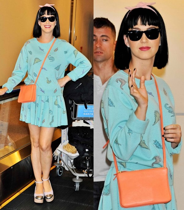 Singer Katy Perry wears a dinosaur-print outfit upon arrival at Narita International Airport