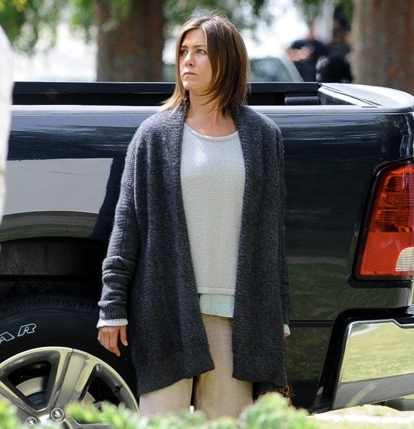 Jen Aniston's grey, white, and khaki outfit match the gloomy theme of the movie