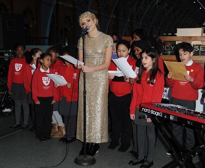 Pixie Lott performing with children from Copenhagen Primary School to raise funds for Penny for London at St. Pancras International in London on December 16, 2014