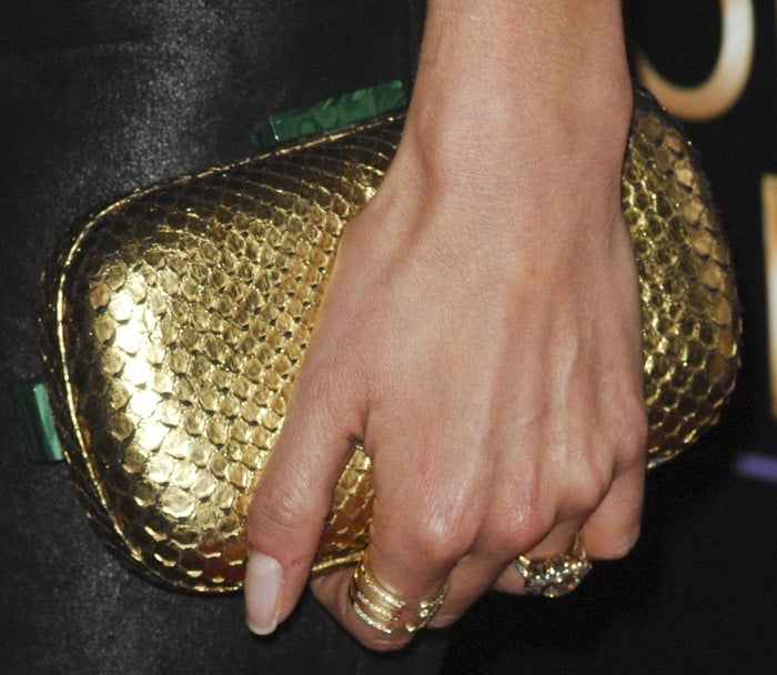 Nikki Reed complements her gold Corto Moltedo clutch with a selection of gold rings