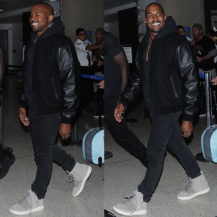 Kanye West rocks a casual all-black outfit, pairing a stadium jacket with faded jeans and his signature Yeezy 750 Boost sneakers at LAX