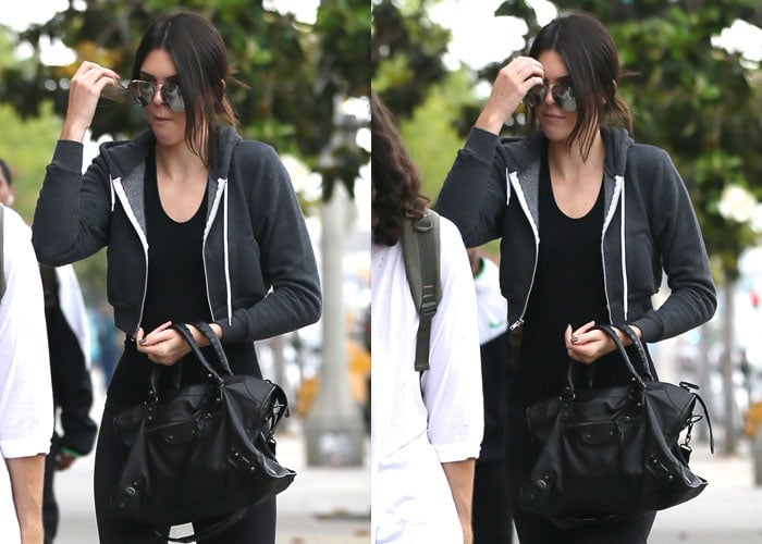 Kendall Jenner keeps it casual yet chic in an American Apparel tank, a black Balenciaga tote, and reflective Victoria Beckham sunglasses