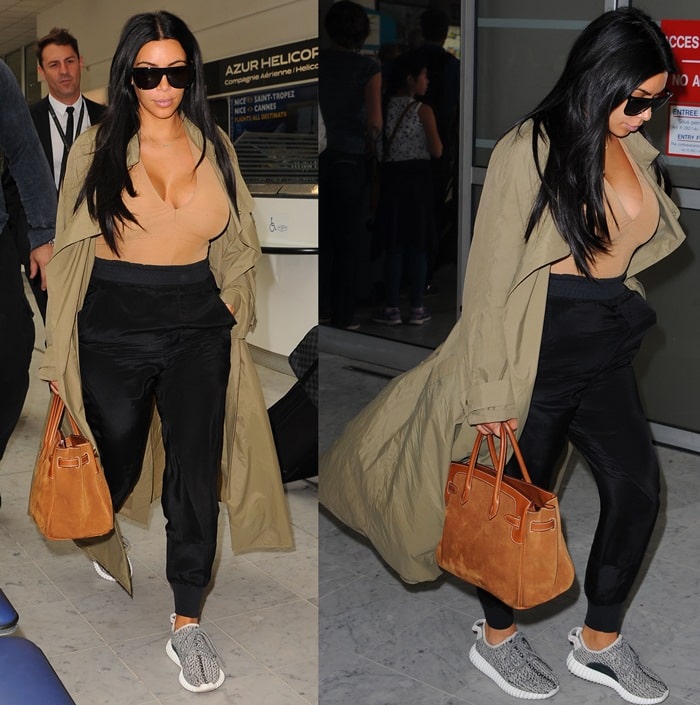 Kim wore neutral tones for her airport stroll, opting Haider Ackermann jogging bottoms, a suede Hermes bag, an olive duster jacket and a pair of "Yeezy 350 Boost" sneakers