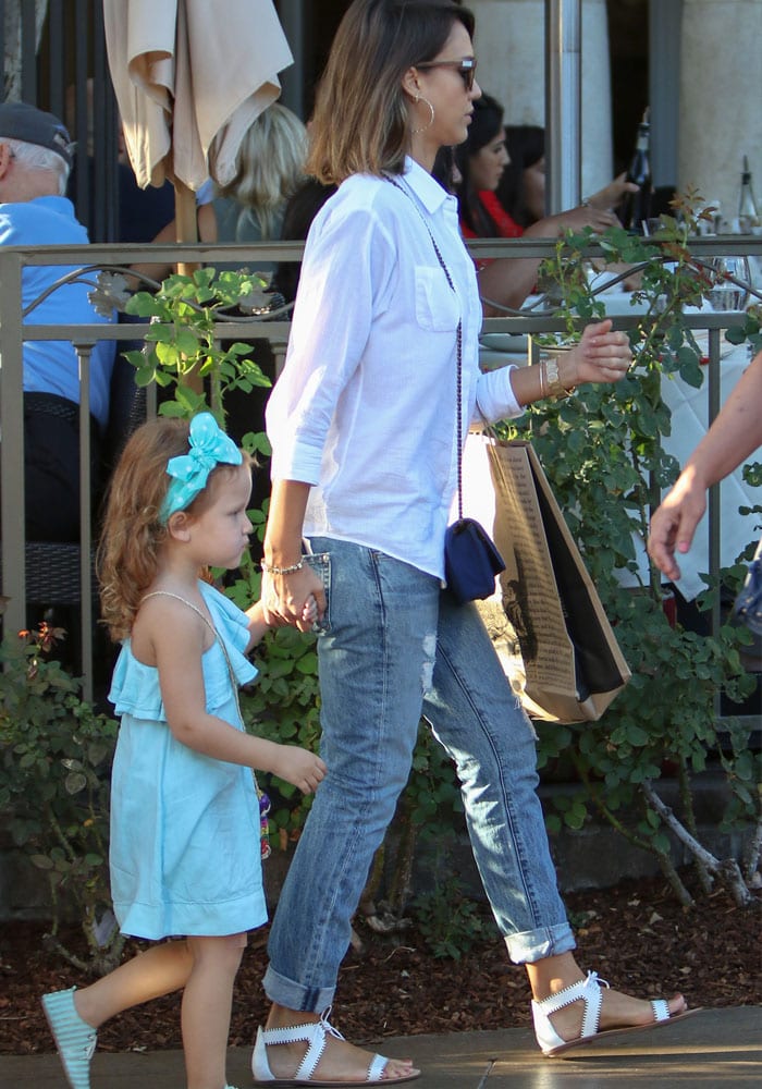 Jessica Alba looks casual and chic in flat white sandals, jeans and a simple white button-up