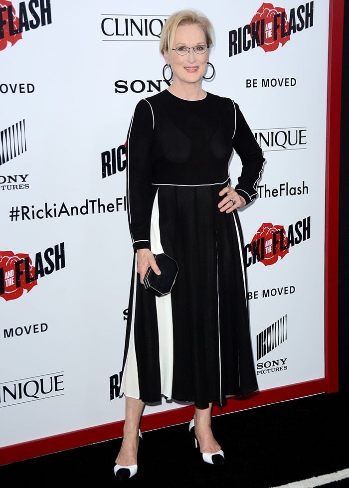 Meryl Streep accessorized with black hoop earrings and a black clutch