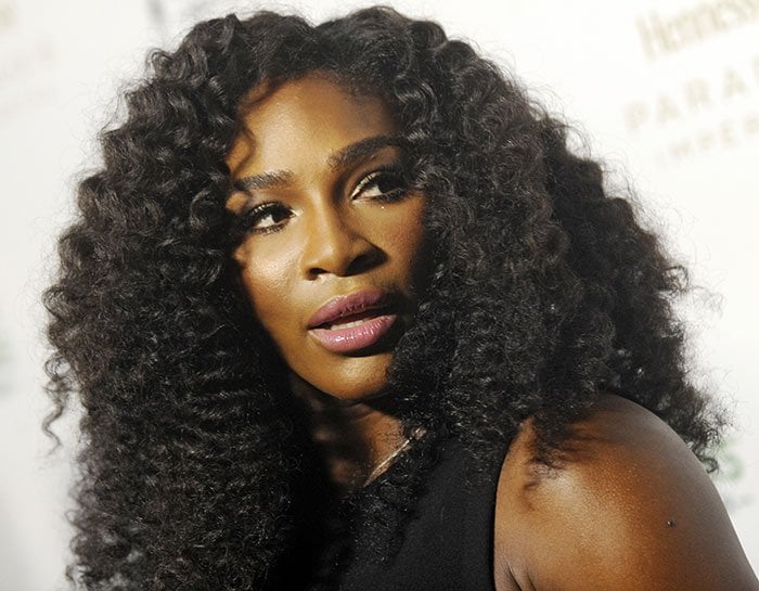 Serena Williams' voluminous curly hairstyle with an off-center parting