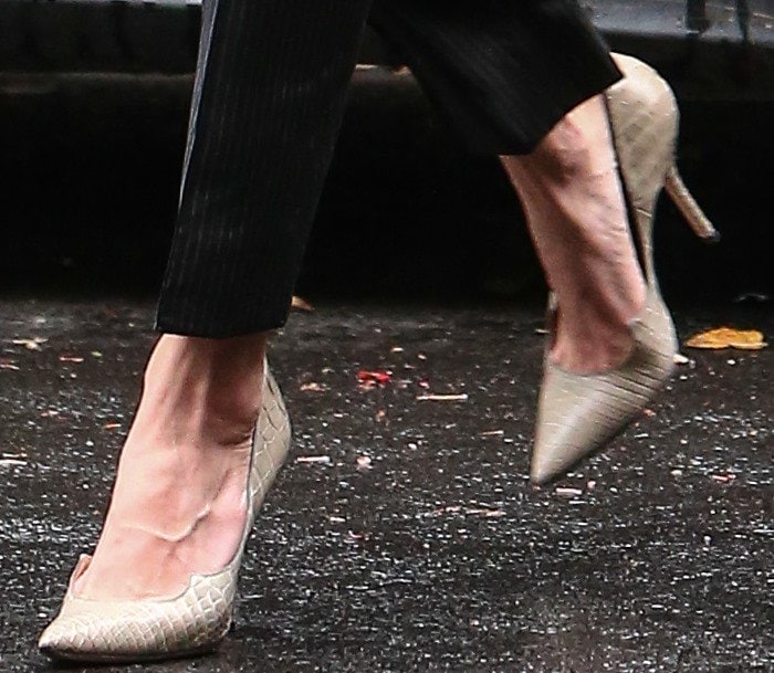 Amal Clooney steps stylishly through the rain in her elegant Paul Andrew pumps, showcasing their signature scalloped-edge design and sleek pointed toe