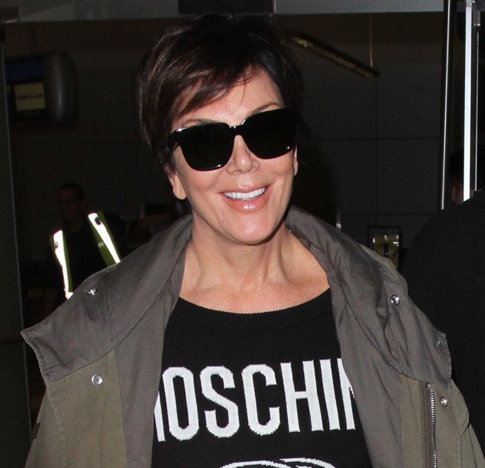 Kris Jenner vistiendo un suéter Moschino negro estampado en el Aeropuerto Internacional de Los Ángeles