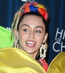 Miley Cyrus in Ridiculous Flower Dress and Green Inflatable Mules