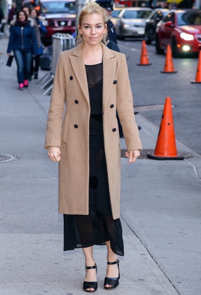 Sienna Miller wears a camel coat over a Roland Mouret dress in New York City