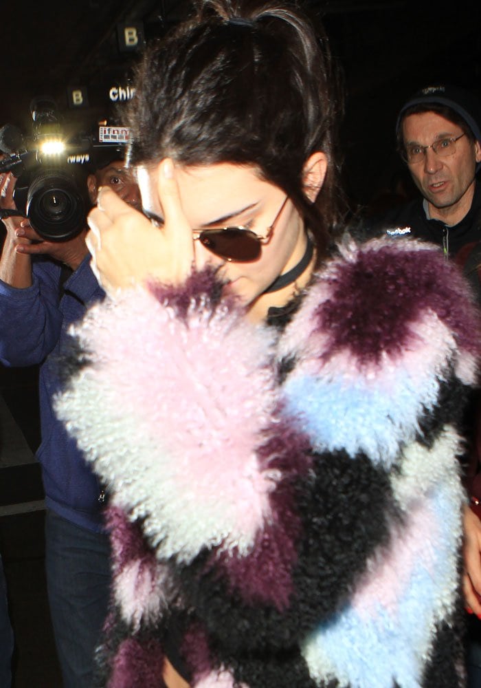 Kendall Jenner shields her face and wears her hair back as she arrives at Los Angeles International Airport