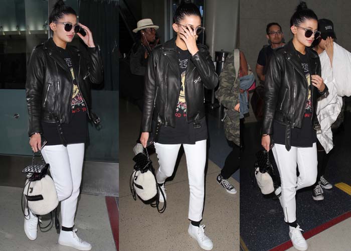 Kylie Jenner arrives at LAX wearing a leather jacket overtop a Yeezy shirt