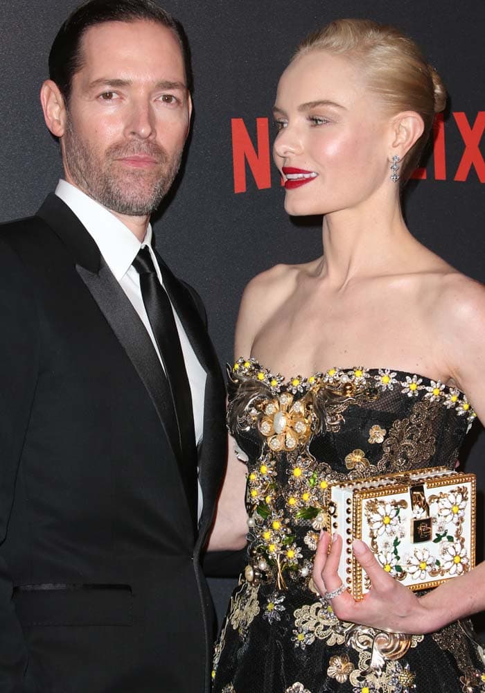 Joined by her husband Michael Polish, Kate Bosworth carries a box clutch to a Golden Globes after-party