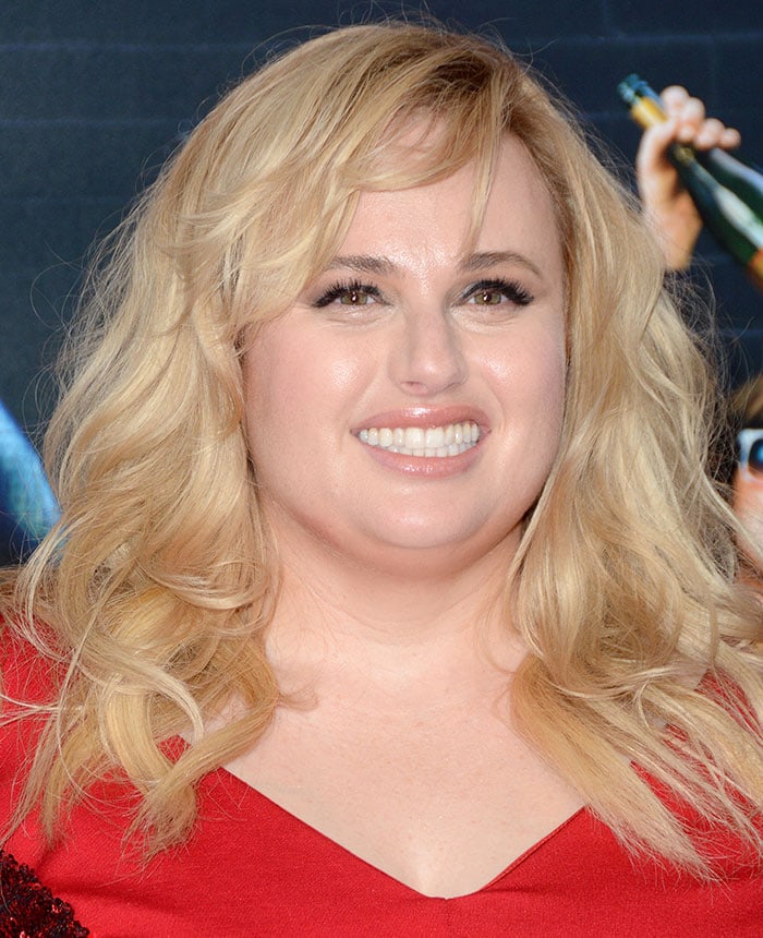 Rebel Wilson Shimmers in Red Torrid Dress and Casadei Pumps
