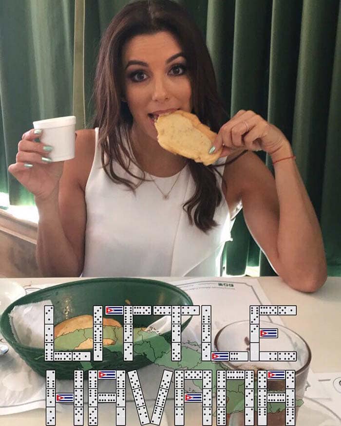 Eva Longoria enjoys a Cuban snack while visiting Little Havana, capturing a fun moment of cultural exploration