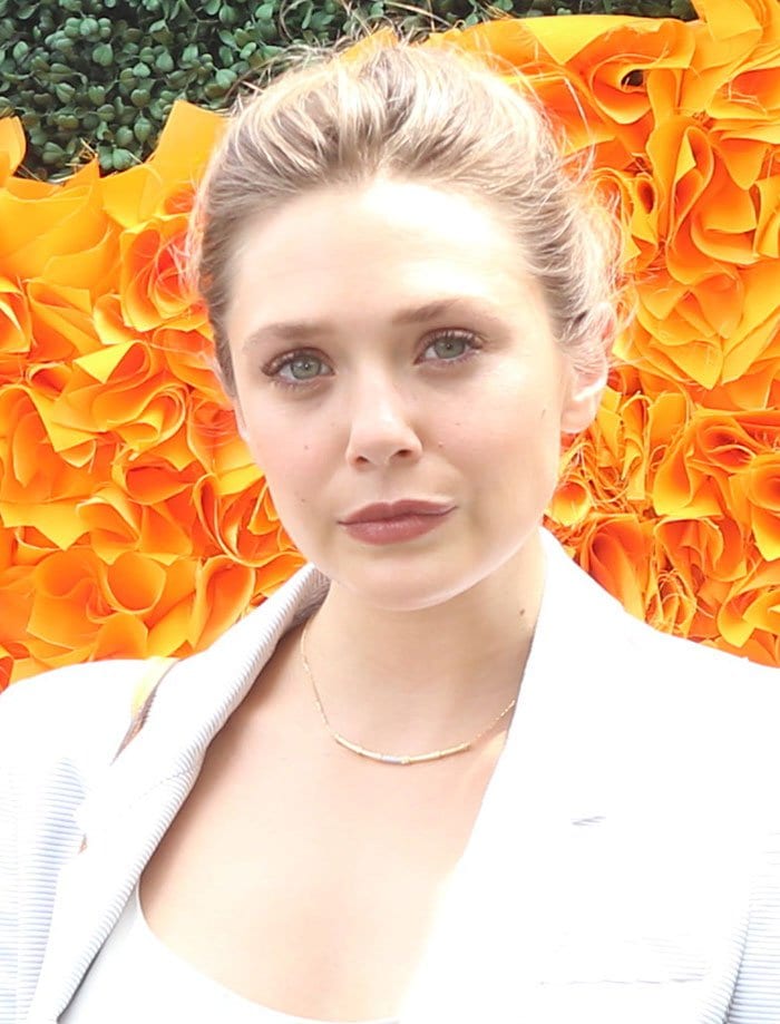 Elizabeth Olsen pulls her hair back at the 9th annual Veuve Clicquot Polo Classic