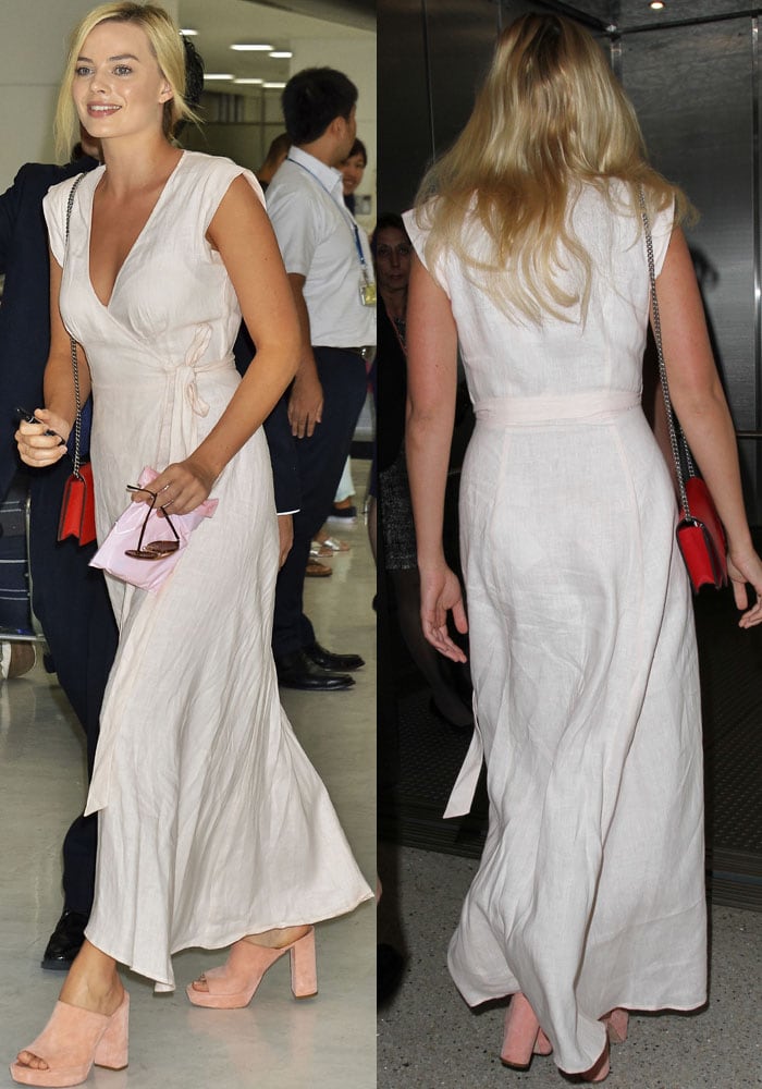 Margot Robbie donning a stunning white wrap-around maxi dress from Reformation, proving that you can bring runway-worthy elegance to your travel attire