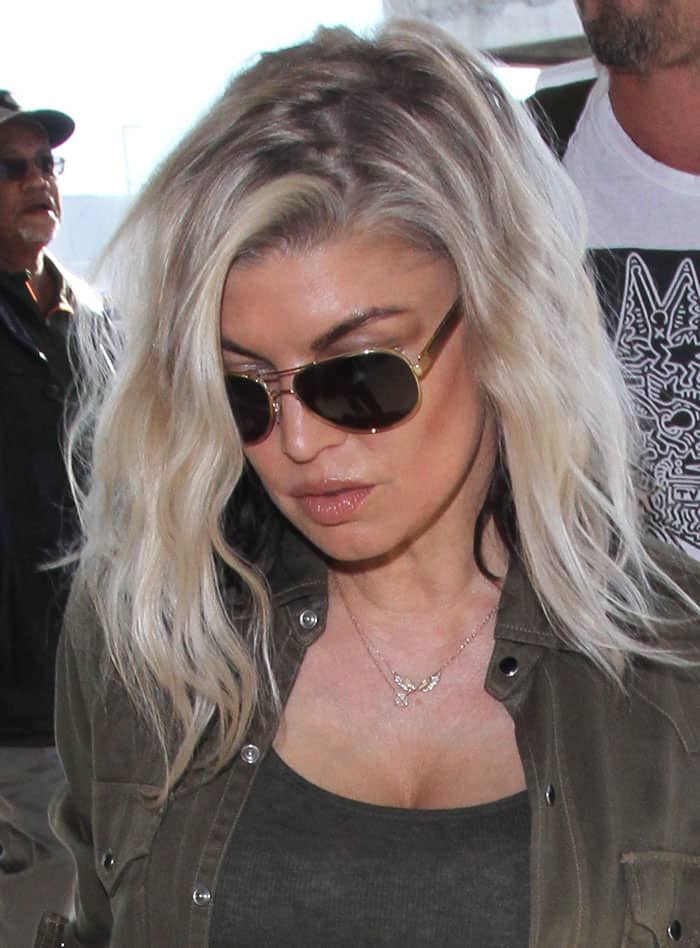 Fergie completes her casual look with tousled waves, aviator sunglasses, and a delicate butterfly necklace