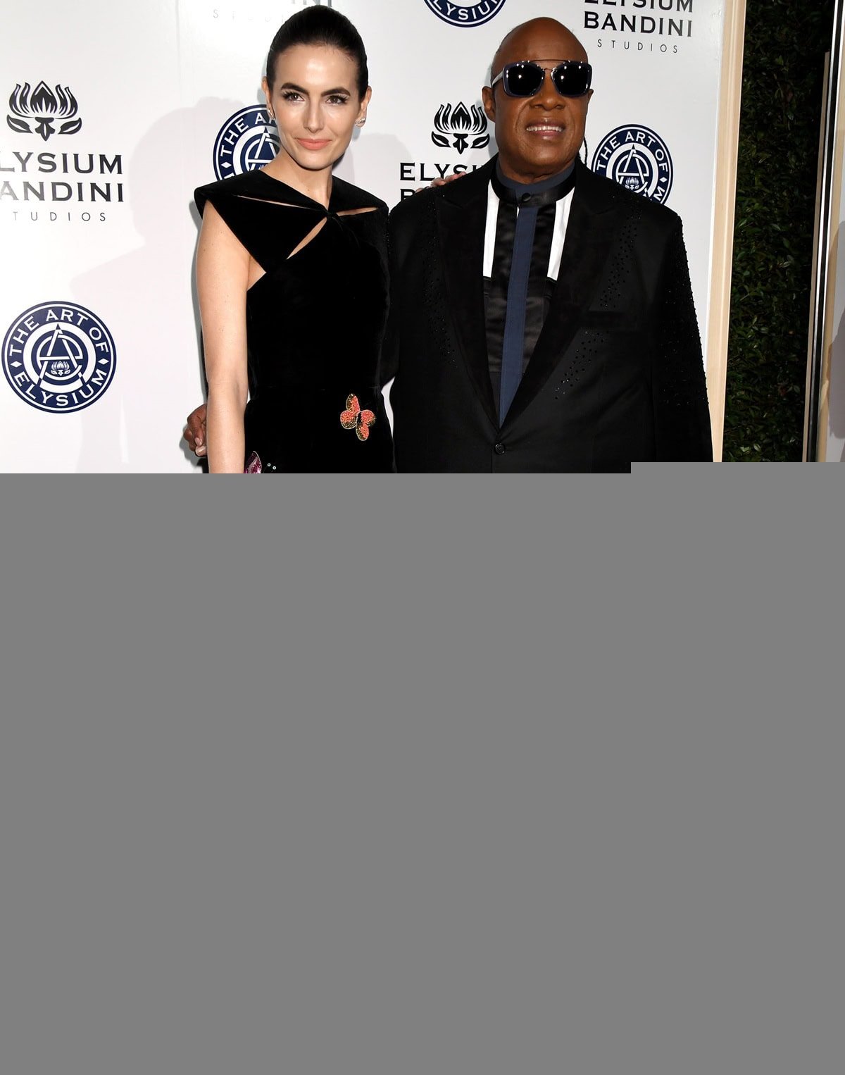 Camilla Belle and Stevie Wonder attend the 10th annual Art of Elysium "Heaven" Gala, celebrating the organization's 20th anniversary, with Belle wearing an elegant, embroidered gown