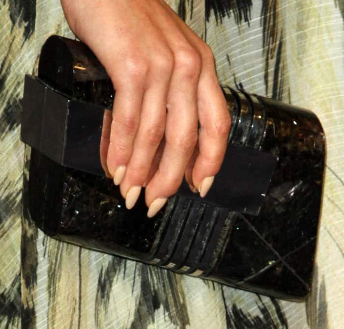 Cara accessorizes her look with an Emm Kuo clutch