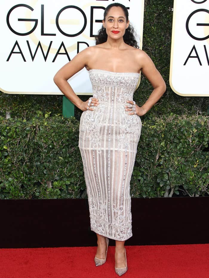 Tracee Ellis Ross stuns on the Golden Globes red carpet in a strapless, intricately embroidered gown paired with diamond rings on every finger for a bold, glamorous look