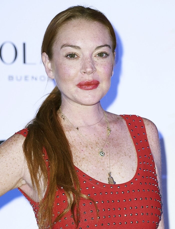 Lindsay Lohan showed off her cleavage in a studded crimson dress featuring a low-cut neckline