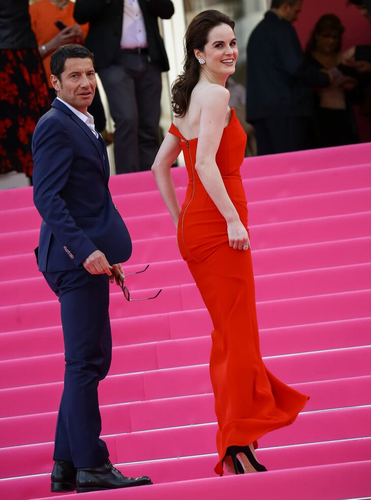 Michelle Dockery's black stiletto heels made a brief but striking appearance as she ascended the stairs, perfectly complementing the elegant open-back design of her red Roland Mouret gown