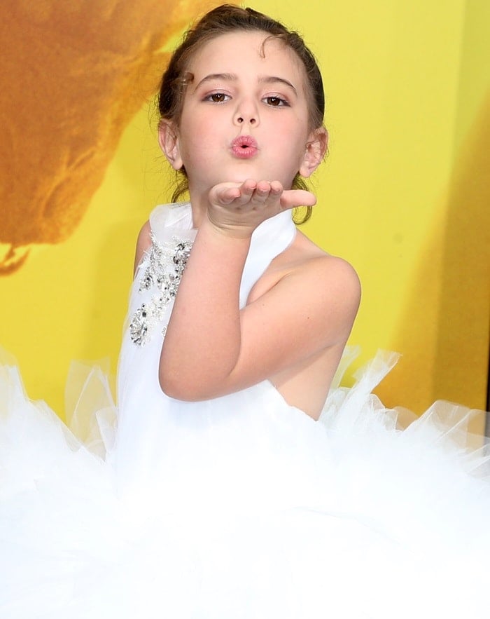 Lexi Rabe blows a kiss in a white feathered gown by Isabella Couture