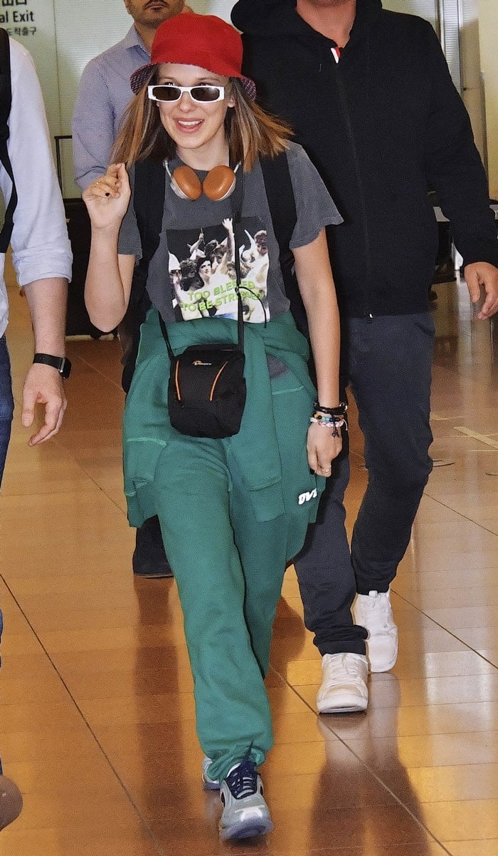 Stranger Things star Millie Bobby Brown arrives at Tokyo International Airport in forest green OVO sweatpants