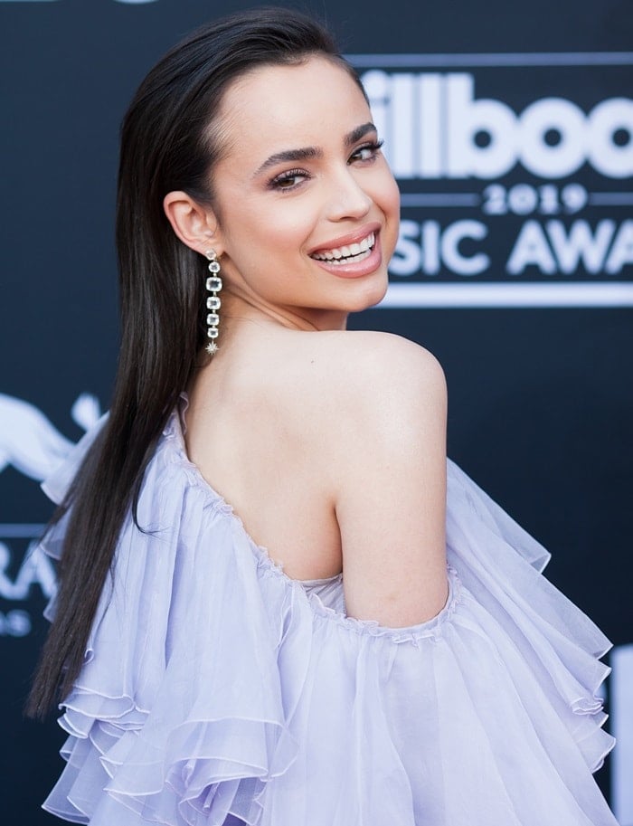 Sofia Carson showed off her Moonlight earrings in a one-shouldered, floor-length lavender gown