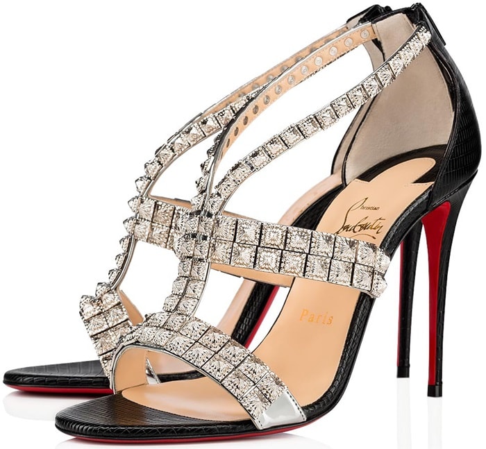 Glinting pyramid studs and reptile-embossed leather add rich texture to a strappy sandal finished with a willowy stiletto and that famed red sole