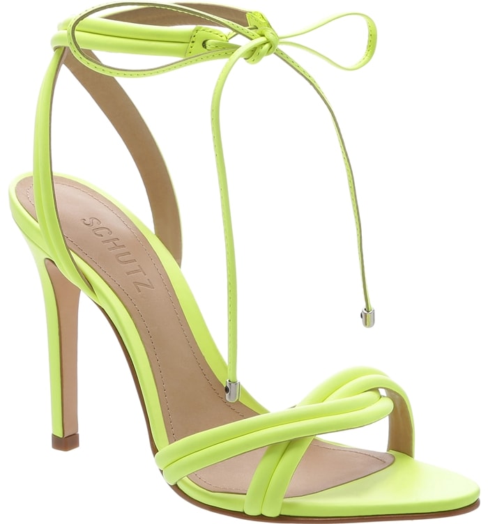 Plump, segmented straps entwine over the toe and wrap above the ankle of a towering leather neon yellow sandal finished at the front with a metal-tipped bow