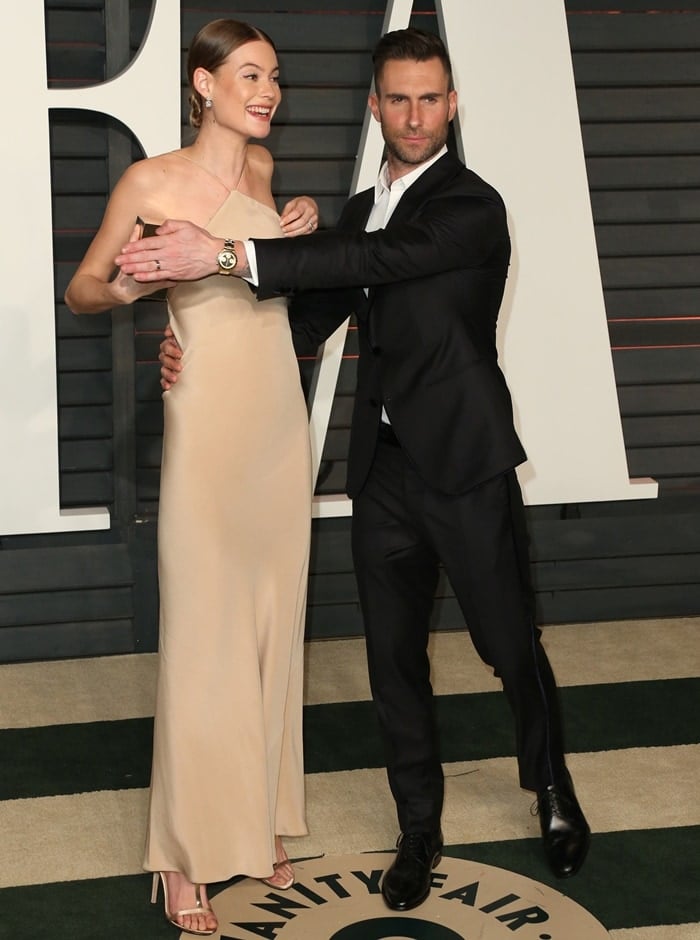 Adam Levine holds his hand over Behati Prinsloo's chest to hide a nip slip at the 2015 Vanity Fair Oscar Party